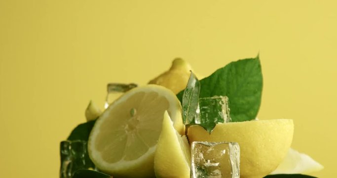 composition of lemons, leaves and ice cubes. Covered by water drops. Fresh summer fruit composition