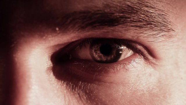 Young caucasian man opens and closes his eye. 4K close-up shot