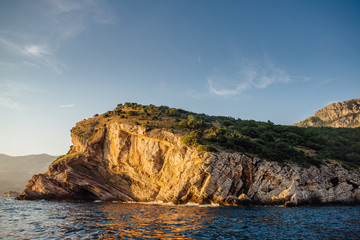 Fototapeta premium Rocky coast of the Adriatic Sea in Montenegro at sunset, view from the sea