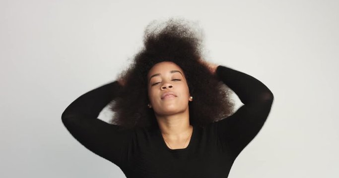 beuayt black woman with a huge afro hair having fun smiling and touching her hair