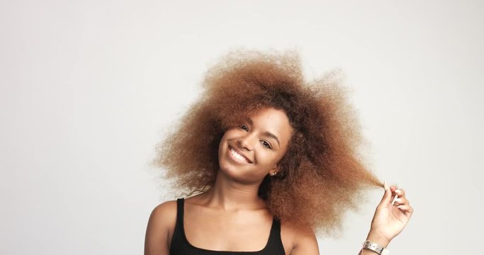 beuayt black woman with a huge afro hair having fun smiling and touching her hair