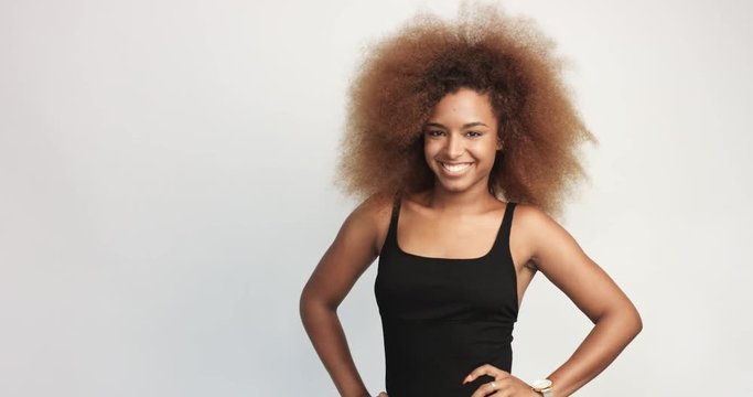 beuayt black woman with a huge afro hair having fun smiling and touching her hair