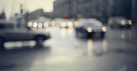Blurry unfocused background with the city road with cars in twilight