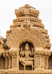 Nanjangud, India - October 26, 2013: Niche in beige elaborately decorated sandstone at Srikanteshwara Temple showing statue of Lord Shiva sitting on Nandi the bull. 