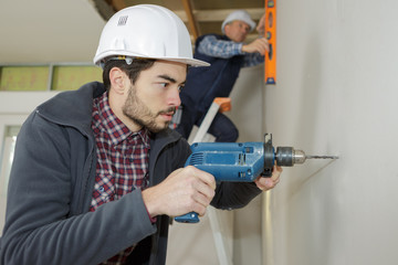 construction site workers drilling with a machine or drill