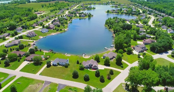 Summer aerial flyover of beautiful Lake lined with idyllic homes.

