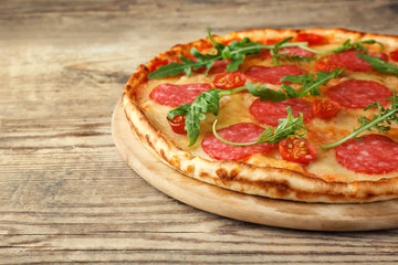 Pizza with salami on wooden background