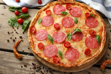Pizza with salami on wooden table closeup