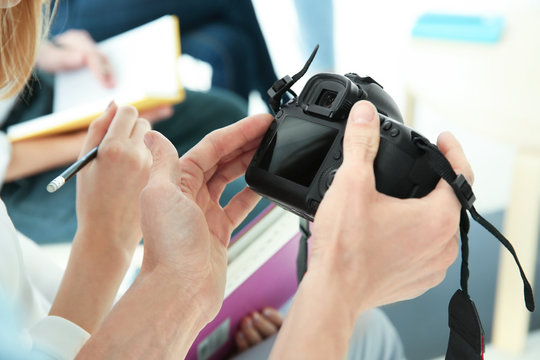 Male instructor holding digital camera during photography classes