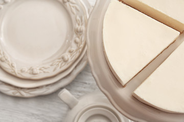 Dessert stand with delicious sliced cheesecake on table