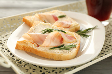Tasty toasts with bacon and cup of coffee for breakfast on tray