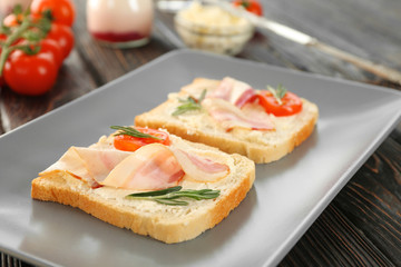 Tasty toasts with bacon for breakfast on plate