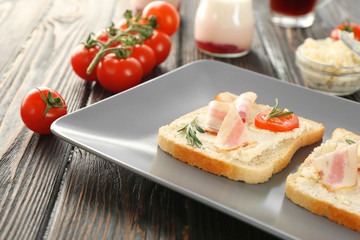 Tasty toasts with bacon for breakfast on plate