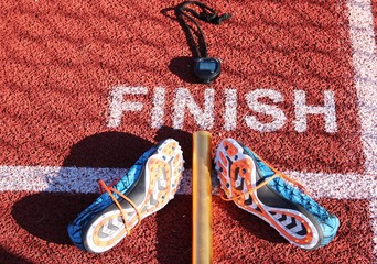 Stopwatch, baton and spikes at finish line