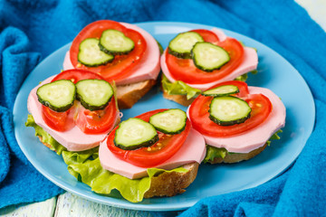 Bruschetta with salad, sausage, tomato and cucumber