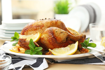 Homemade baked chicken with lemon and mint on table