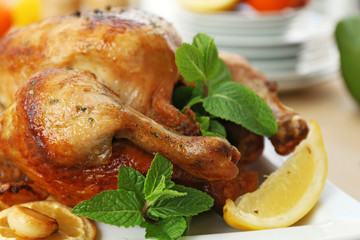 Homemade baked chicken with lemon and mint on table