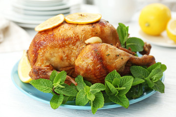 Homemade baked chicken with lemon and mint on table