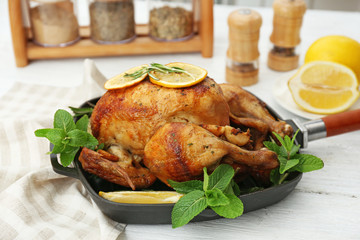 Homemade baked chicken with lemon and mint on table