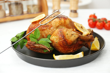 Homemade baked chicken with lemon and mint on table