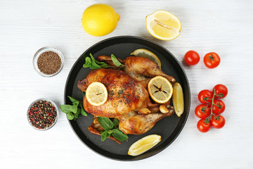 Homemade baked chicken with lemon and mint on table