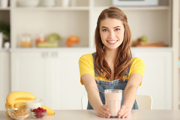 Weight loss concept. Beautiful young woman with healthy delicious smoothie in kitchen