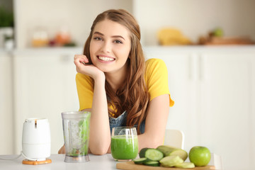 Obraz na płótnie Canvas Weight loss concept. Beautiful young woman with fresh green smoothie in kitchen