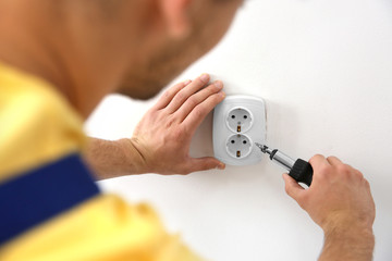 Electrician repairing socket, closeup