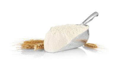 Fototapeta na wymiar Metal scoop with flour and wheat ears on white background