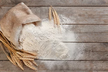 Fotobehang Bag with white flour on wooden background © Africa Studio