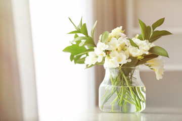 Beautiful bouquet with white freesia flowers on table at home