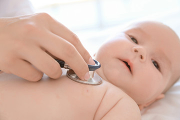 Doctor examining little baby with stethoscope in clinic, closeup. Baby health concept