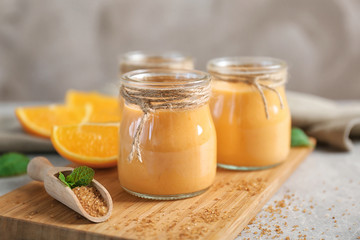 Delicious yogurt smoothie with orange on grey background