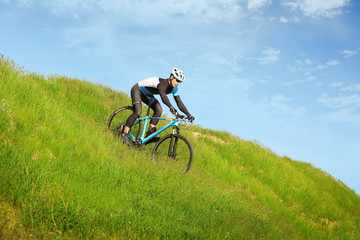 Naklejka na ściany i meble Sporty cyclist riding bicycle in countryside