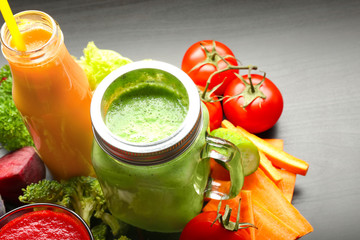 Fresh smoothies and vegetables on table