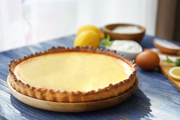 Plate with tasty lemon curd pie on wooden table, closeup
