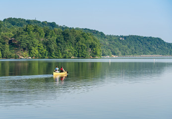 Couple paddling in yellow canoe on tree lined lake