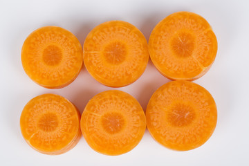 Closeup of sliced fresh carrot arranged over white.