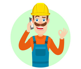 Builder talking on mobile phone and showing a okay hand sign