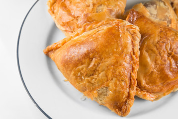 Malaysian cakes, crispy curry puff pastry on white plate