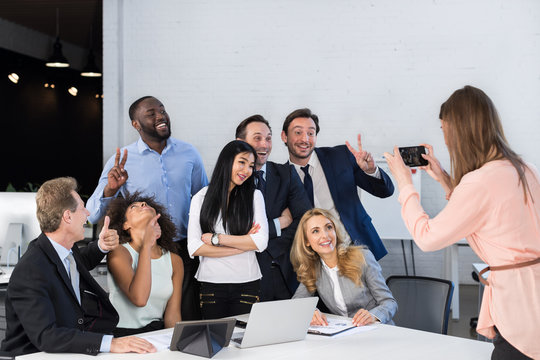 Big Group Of Business People In Office Together, Businesswoman Taking Photo Of Colleagues On Cell Smart Phone, Team Meeting Mix Race Coworkers Businesspeople Happy Smiling Sitting At Desk