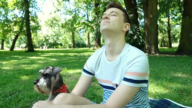 Boy relaxing in the park with his cute dog, steadycam shot
