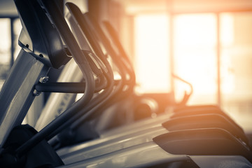 close up treadmill in fitness room background with color tone and light flare effect