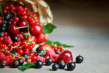 Ripe berries in a basket on a wooden table.