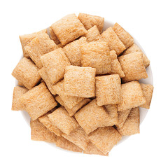 Golden pads corn flakes in white bowl isolated, top view. Cereals.