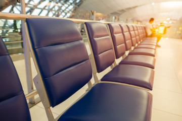 Bench in the terminal of airport , waiting area with chairs.