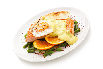Grilled salmon with sauce, fried egg and vegetables on white background 