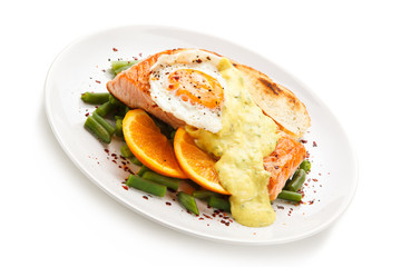 Grilled salmon with sauce, fried egg and vegetables on white background 