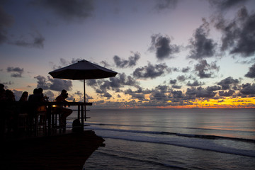 Silhouette of people at bar sunset background