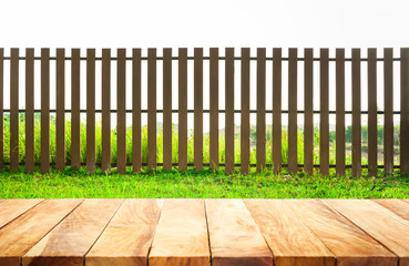 Wood table top with fence and grass in garden background.For  create product display or key visual...